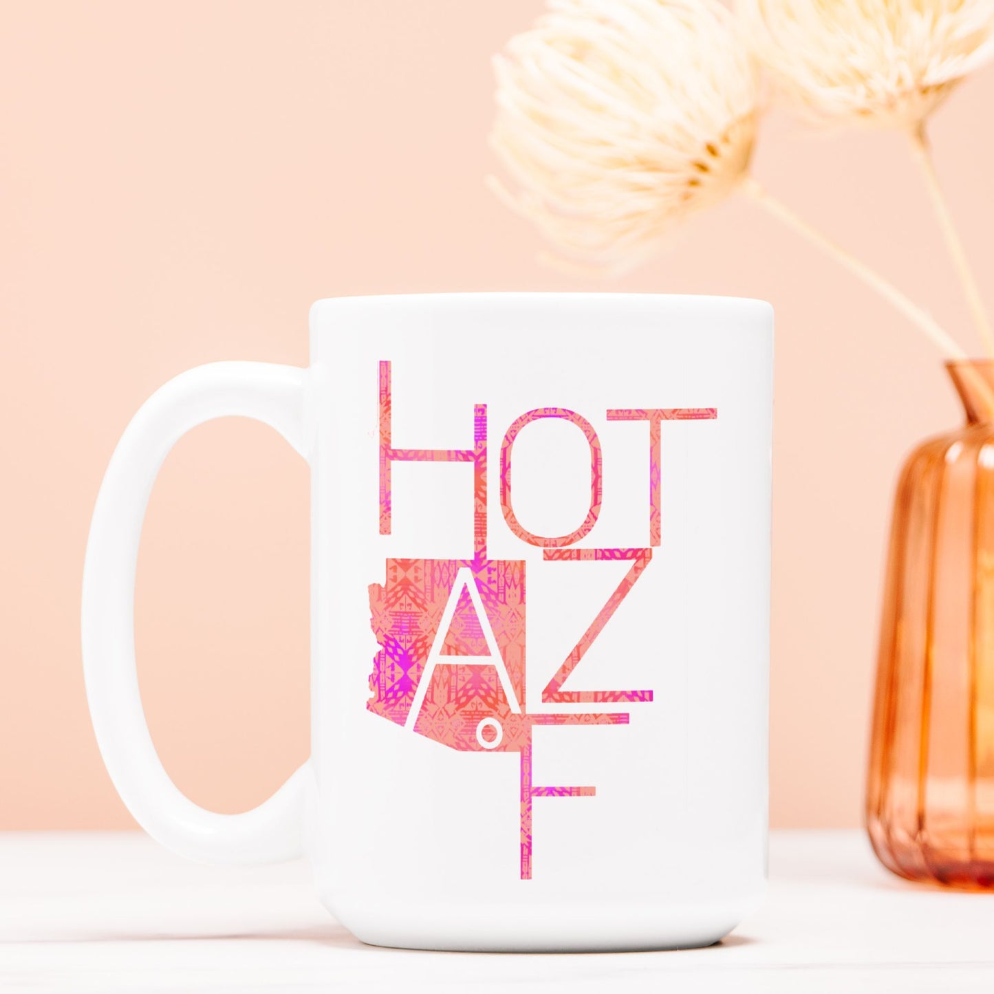 White mug with 'HOT AZ F' design on a peach background