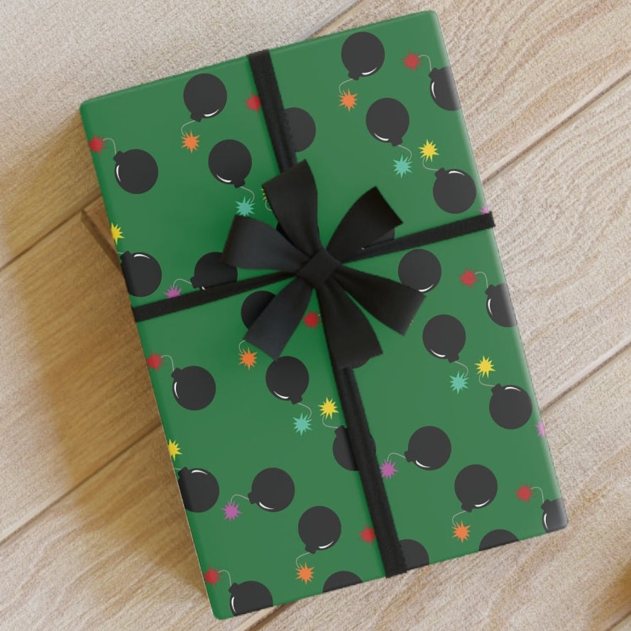 Green gift box with black polka dots and ribbon on a wooden floor