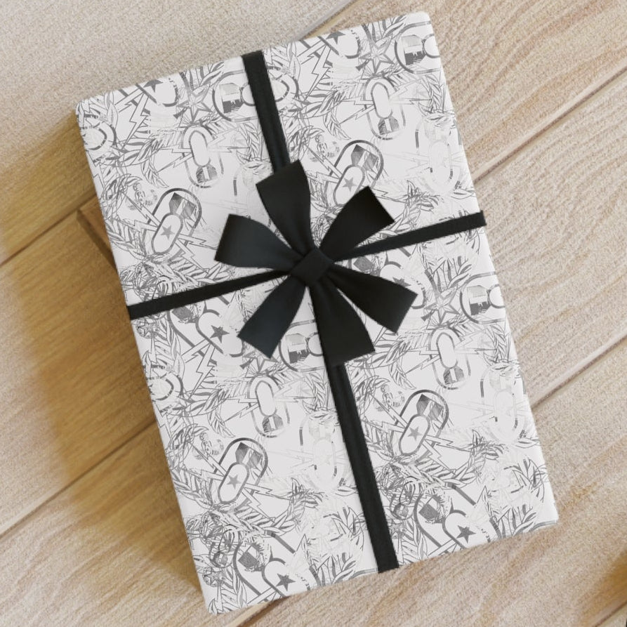 Gift box with black ribbon on a wooden floor with stationery items.