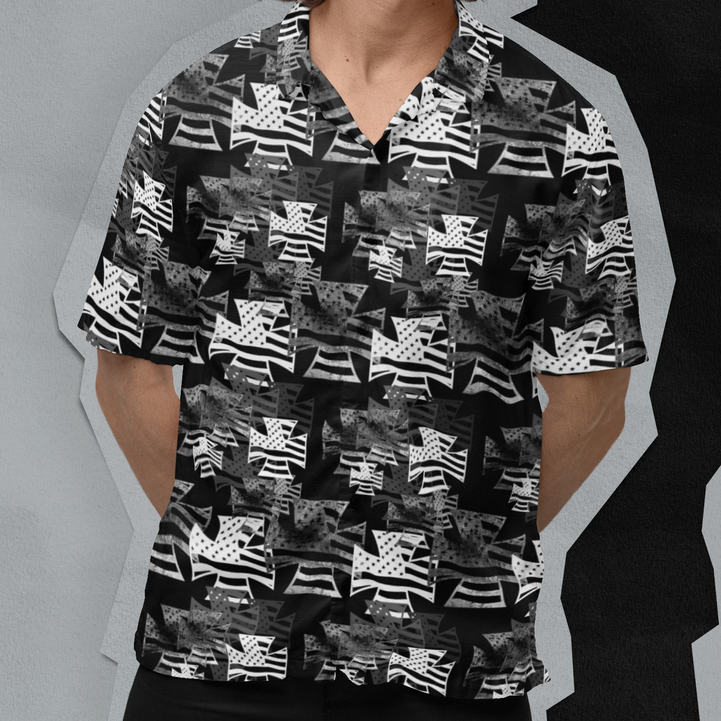 Man wearing a black and white patterned shirt with sunglasses against a gray background