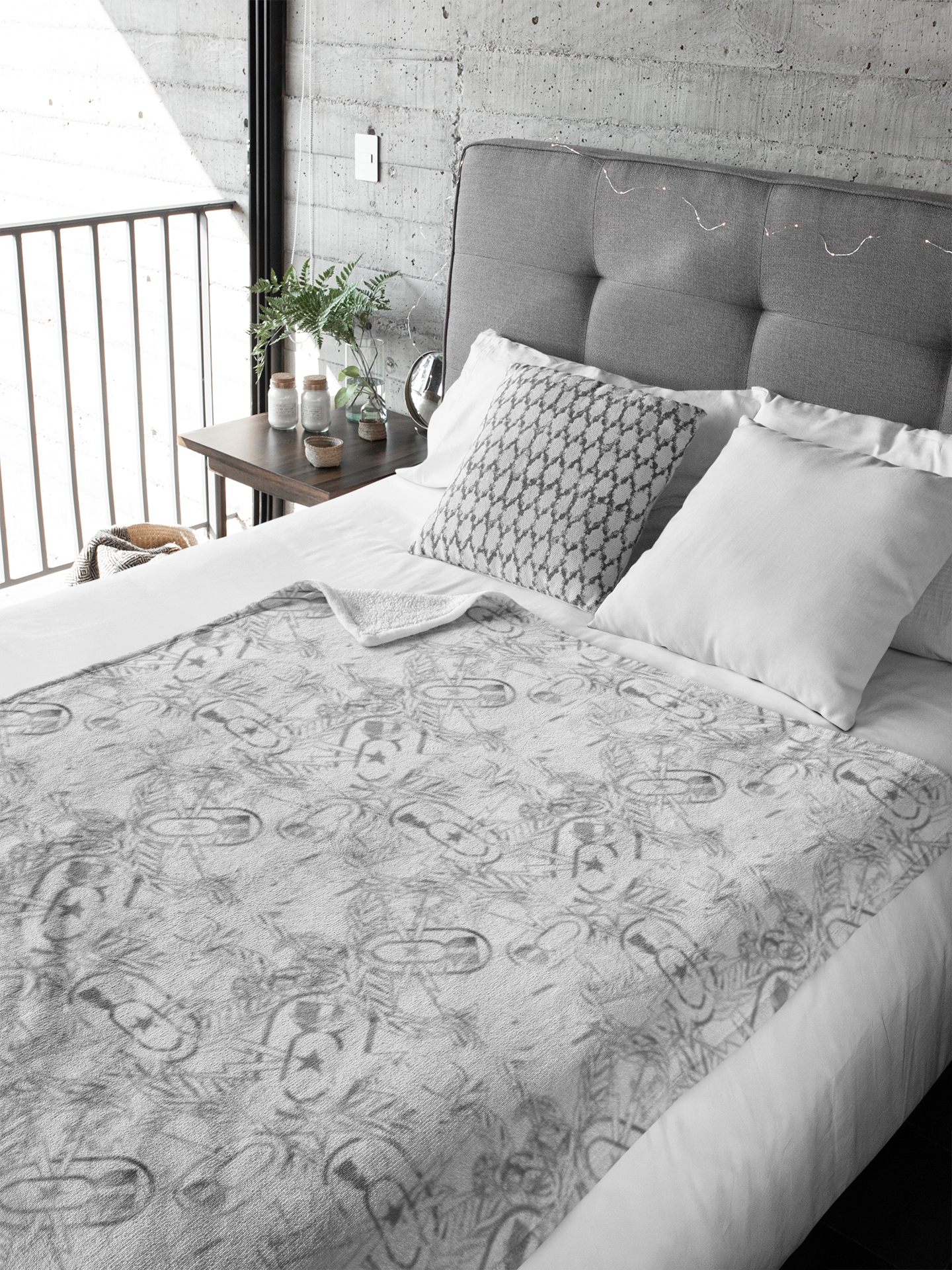 Bed with patterned comforter and pillows in a room with a concrete wall.